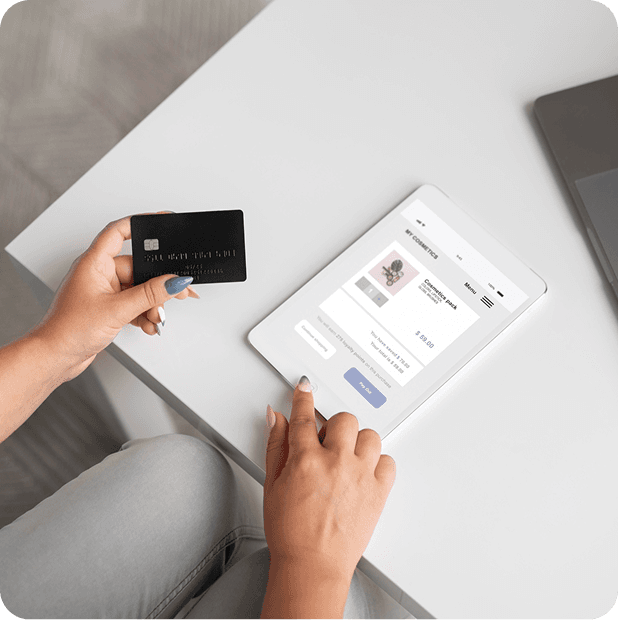 Customer paying for a purchase from a tablet with a credit card in hand