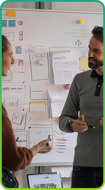 Team discussing wireframes in front of a whiteboard