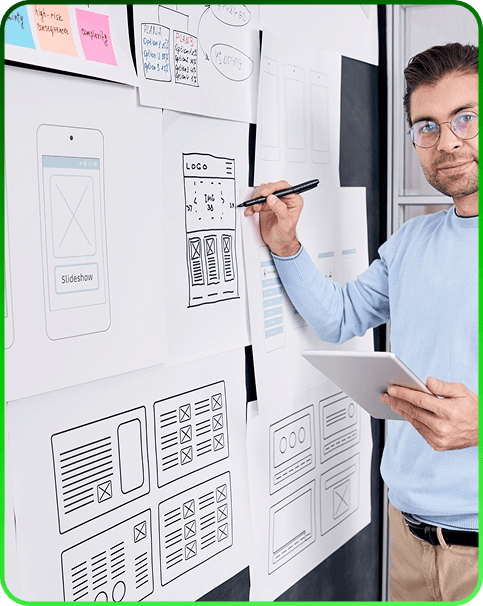 Product designer drawing app wireframes on a wall with sticky notes and sketches
