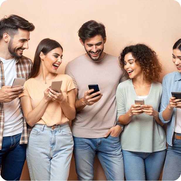 Group of young people celebrating together while looking at their mobile phones